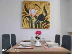 a dining room table with a painting on the wall at "Athena 3" luxury's apartments in Athens !!! in Athens