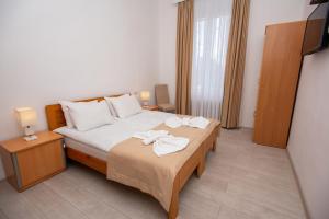 1 dormitorio con 1 cama con 2 toallas en Lowell Hotel, en Tiflis