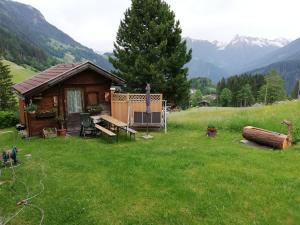 a small cabin in a field with mountains in the background at Appartement Neumann in Finkenberg