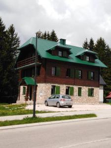 a large house with a car parked in front of it at Apartments Durmitor in Žabljak