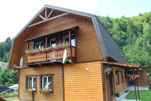 a house with a balcony with flowers on it at Cottage Milena in Mykulychyn