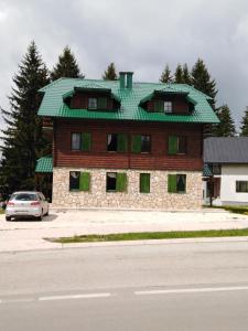 a building with a green roof on top of it at Apartments Durmitor in Žabljak