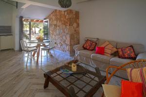 a living room with a couch and a stone wall at Finca Arbequina in Pájara