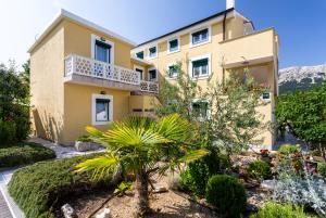 a house with a garden in front of it at Apartments Marija in Baška