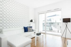 - un salon blanc avec un canapé blanc et une grande fenêtre dans l'établissement A&D Apartment by Renters, à Varsovie