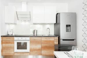 a kitchen with white cabinets and a refrigerator at A&D Apartment by Renters in Warsaw