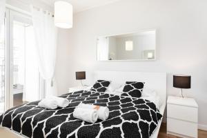 a black and white bed with two towels on it at A&D Apartment by Renters in Warsaw