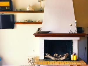 uma sala de estar com lareira e lareira em Seaside House em Aigio