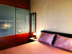 een slaapkamer met een bed met paarse kussens en een tafel bij Seaside House in Aigio