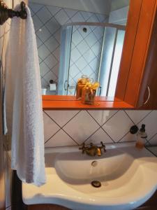 een wastafel met een witte handdoek en een spiegel bij Seaside House in Aigio +17 foto's