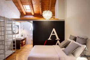 アオスタにあるAlp Apartments - Tourneuve5のベッドルーム1室(大型ベッド1台、壁にアルファベット1台付)