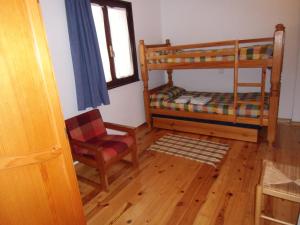 a room with a bunk bed and a chair at Bielva Céntrico con Vistas in Bielva