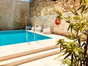 a swimming pool in a building with a stone wall at Hotel Carbonell in Llança