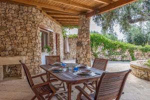 uma mesa de madeira e cadeiras num pátio em Casa Vacanze Galatea em Gagliano del Capo