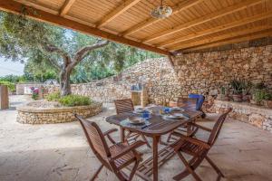 una mesa de madera y sillas en un patio en Casa Vacanze Galatea en Gagliano del Capo