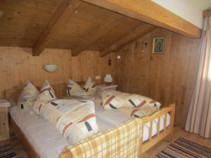 a large bed in a room with wooden walls at Ferienwohnung Spitaler Unterkofler in Hippach