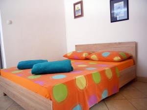 sypialnia z łóżkiem z kolorową pościelą i poduszkami w obiekcie Apartment Gaga and Nia w Krku