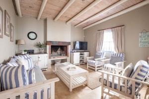 ein Wohnzimmer mit Möbeln und einem Kamin in der Unterkunft Na Genoeg Holiday Home in Paternoster