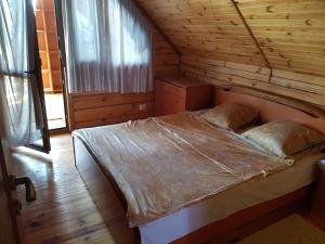 a bedroom with a bed in a wooden cabin at Two Floors House on Chernomorskaya in Bolʼshaya Balabanka