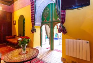 un soggiorno con un vaso di fiori su un tavolo di Riad le dromadaire bleu by Weekome a Marrakech
