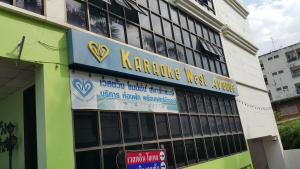 a building with a sign on the side of it at West Wing Mansion in Bangkok