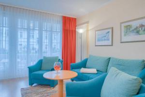 ein Wohnzimmer mit einer blauen Couch und einem Tisch in der Unterkunft Villa Elfeld 2 Whg. 717 in Binz