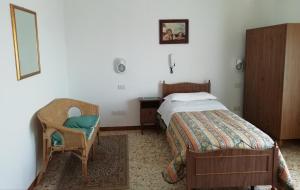 a bedroom with a bed and a chair at Albergo La Torre in Radicofani