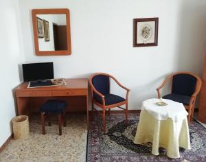 a room with a desk and two chairs and a mirror at Albergo La Torre in Radicofani