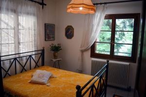 - une chambre avec un lit et une couverture jaune dans l'établissement The House with the Hydrangeas, à Elati