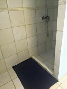 y baño con ducha y alfombra negra. en Apartment TJK, en Sveti Filip i Jakov