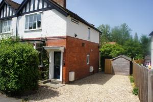 a white and red brick house with a garage at Magnolia Cottage in Church Stretton
