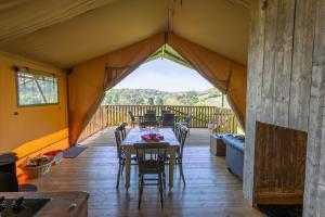 a tent with a table and chairs on a deck at Valleyside Escapes in Tiverton