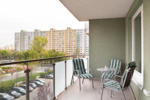 a balcony with chairs and a table and a building at Great tourist and business Apartment near center in Bratislava