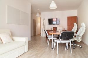 a living room with a white couch and a table and chairs at Great tourist and business Apartment near center in Bratislava
