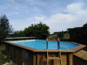 a swimming pool with a chair on a wooden deck at Gite Evidence in Varennes-sur-le-Doubs