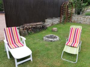twee stoelen en een vuurplaats in een tuin bij Domino in Korytné