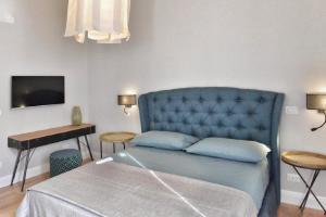 1 dormitorio con cama azul y escritorio en Domus D'Angelo B&B en Formia