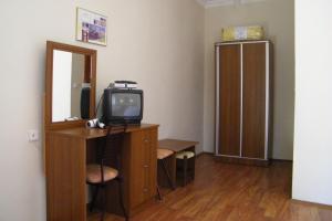Habitación con escritorio, TV y espejo. en Hotel Aşıkoğlu, en Bogazkale