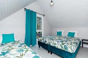 a bedroom with two beds and a window at Villa6 I Domki Pobierowo in Pobierowo