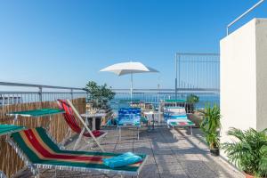 a patio with chairs and tables and an umbrella at Residence Baltic in Cattolica
