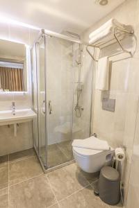 a bathroom with a shower and a toilet and a sink at Comfort Suites in Alanya