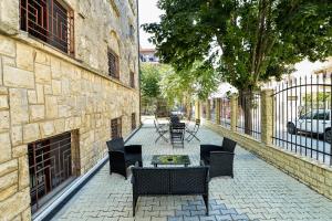 a patio with chairs and a table on a sidewalk at Vila Sabarel in Eforie Sud