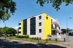 a yellow and white building on the side of a street at B&B HOTEL Cholet Sud in Cholet