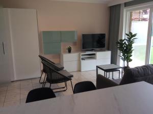 a living room with a tv and a table and chairs at residentie Den Oever in Nieuwpoort