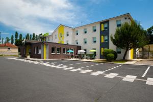 ein leerer Parkplatz vor einem Gebäude in der Unterkunft B&B HOTEL Brive-la-Gaillarde in Ussac