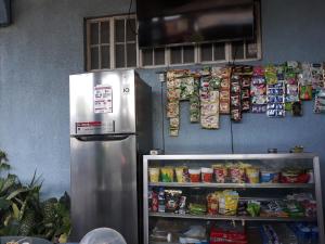 a refrigerator in a kitchen next to a shelf of food at cv bed n bath san juan in Dalumpinas Oeste