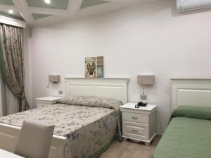 a small bedroom with a bed and two night stands at Stella del Mare in Licata