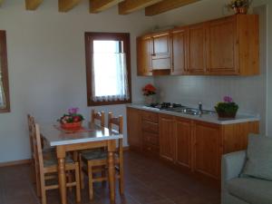 a kitchen with wooden cabinets and a table and a sink at Agriturismo ai Casali in Palazzolo dello Stella