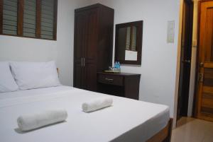 una camera da letto con un letto con due asciugamani sopra di 13 ways Room Rentals a Panglao