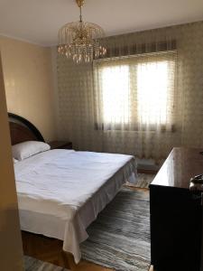 una camera da letto con un grande letto bianco e un lampadario a braccio di Apartament Central Dioda Deluxe a Sibiu